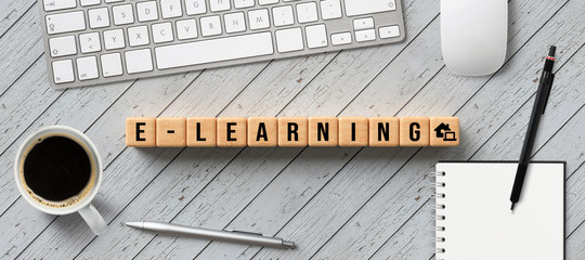 Wall Mural - cubes with message E-LEARNING and computer equipment on wooden background