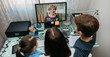 © David Pereiras - Top view of mother and children talking on video call with computer with grandmother