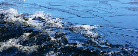 Blue Art. Water Banner. Liquid Ice. Icy Pattern. Ocean Texture. Abstract magical Ice. blue water surface with thin pieces of ice. close-up: thin sheets of ice on the water break from the wave