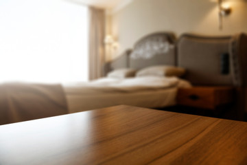 Wall Mural - wooden desk of free space and blurred home interior with bed