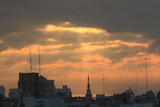 Fototapeta Miasto - el sol nace entre las nubes en una  hermosa mañana en la ciudad de Rosario,Argentina