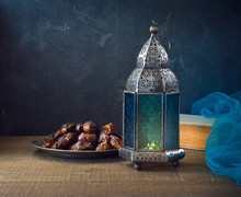 Lightened Lantern And Dates Fruit On Wooden Table Over Dark Background. Ramadan Kareem Holiday Celebration Concept