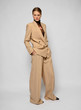 © Streetstylephoto - portrait of a young woman in fashion clothes, shooting in studio. Beige pantsuit