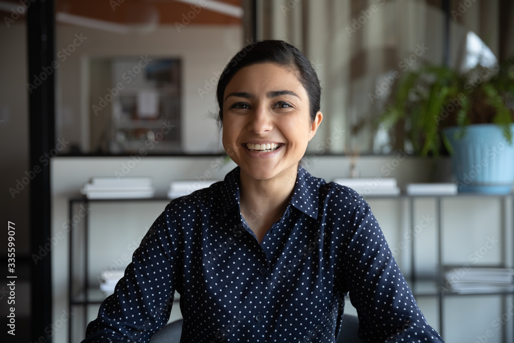 Excited young indian ethnicity woman looking at camera, holding funny conversation with colleagues online, webcam view. Head shot millennial hindu female worker laughing, having fun in office. - obrazy, fototapety, plakaty 