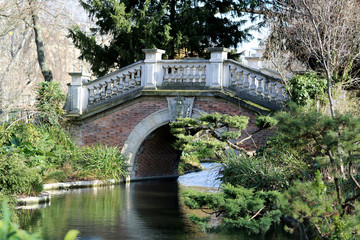 Beautiful old stone bridge with railing over clean river in preserve