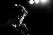 © Hennadii - Young handsome guy emotionally sings and speaks into the microphone. Black and white photography