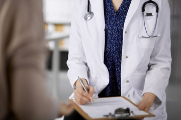 Doctor and patient discussing current health examination while sitting in clinic. Perfect medical service in hospital. Medicine concept