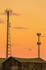 Silhouette in a pair of large transmission towers at sunset