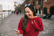 © Mego-studio - Woman holding phone with successful expression.