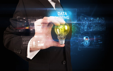 Businessman holding lightbulb with DATA MINING inscription, online security idea concept