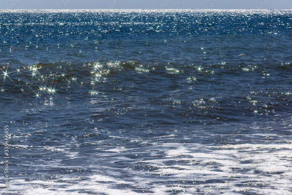 Solar glare in the form of stars on the sea wave. Sparkling sea waves ...