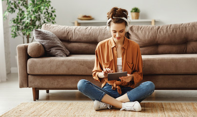 happy pensive woman using digital tablet at home.