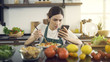 © Natthaphon - Asian Women Eating Salad While Sitting in Modern Kitchen.And looking at the news with a serious expression.While in the house to be detained during an epidemic Coronavirus(Covid-19).