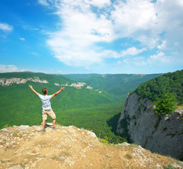 Wall Mural - Man in mountain at day strive hands to sun.