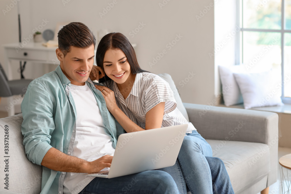 Happy young couple with laptop at home
