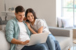 © Pixel-Shot - Happy young couple with laptop at home