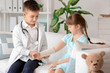© Pixel-Shot - Cute little doctor working with patient in clinic