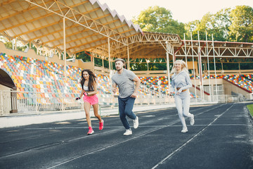 Handsome man at the stadium. Sportswomen in a sportswear. People training