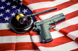 Wooden judge gavel and black color gun over USA flag