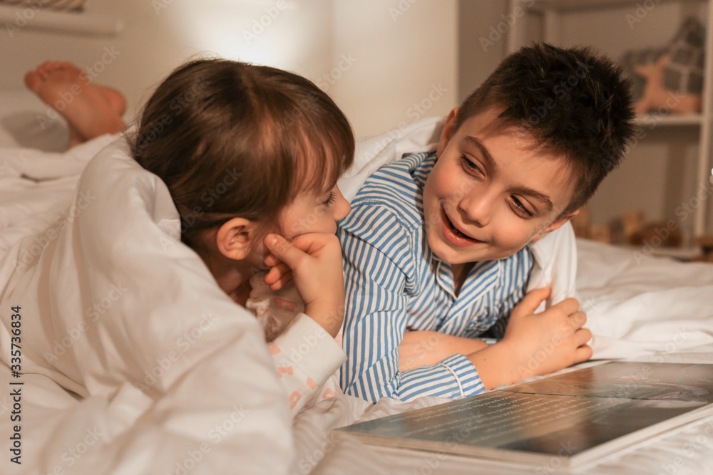 Little children reading bedtime story at home