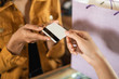 © Odua Images - close up of hand giving credit card in the cashier before checkout
