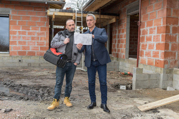 Worker in discussion with the architect on a construction site