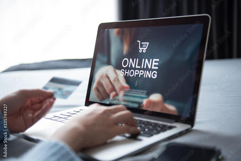 E-commerce and online shopping concept, Woman hand using laptop (Mockup website) and holding credit card for shopping payment online at home.