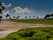 View of the golf field with the blue ocean and trees in the background in the Dominican Republic