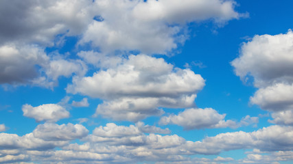 White fluffy clouds on blue sky background in clear weather