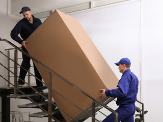 Wall Mural - Professional workers carrying refrigerator on stairs indoors