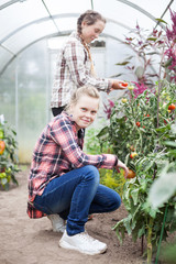 Portrait of   teenage girls in   greenhouse