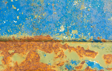 Wall Mural - An old metal case with bright orange spots of rust through several layers of paint.Peeling paint on old rusty metal.