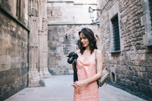 Woman Smiling Using Camera On Old City Street