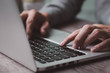 © KTI - businessman hands typing on laptop. Office desk workspace with computer  on wooden table. Flat lay, side view work / business work from home concept