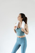 © 浩然 张 - A young Asian woman wipes sweat with a towel in front of a pure white background