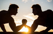 Silhouette of hands that compete in strength. Rivalry, closeup of male arm wrestling. Men measuring forces, arms. Two men arm wrestling. Rivalry, vs, challenge, hand wrestling. Sunset, sunrise