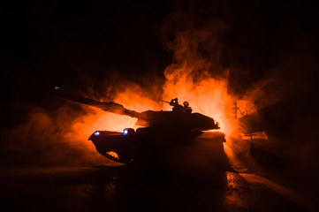 War Concept. Armored vehicle silhouette fighting scene on war foggy sky background at night.