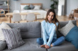 © BestForYou - Pretty woman relaxing on the couch at home in the living room.