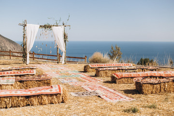 Arch decorated with lively floristics on the background of the sea. Boho style