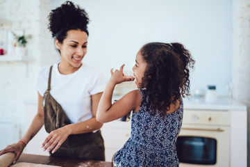 Girl eating homemade cookie in kitchen