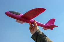 Styrofoam Throwing Plane-glider In The Hand Of A Woman Against The Blue Sky