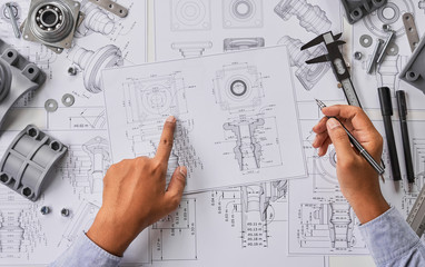 Fototapete - Engineer technician designing drawings mechanical parts engineering Engine.manufacturing factory Industry Industrial work project blueprints measuring bearings caliper tools