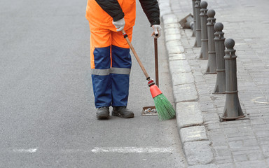 Wall Mural - Road sweeper worker cleaning city street with broom tools. Municipal worker in uniform collecting garbage from road and sidewalk. City cleaning service. Man doing hard manual labor