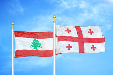 lebanon and georgia two flags on flagpoles and blue cloudy sky