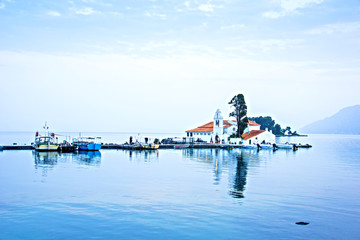 Wall Mural - nice optimistic view of vlacherna monastery on the kanoni peninsula in kerkyra, corfu, greece. popul