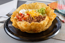 A View Of A Mexican Tostada Taco Salad, In A Restaurant Or Kitchen Setting.
