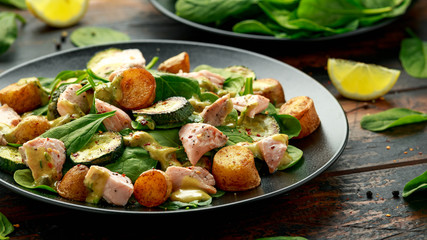 Wall Mural - Salmon, new potato, courgette and spinach salad on wooden table