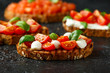 Bruschetta with mozzarella cheese, basil, cherry tomatoes on rustic table