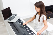 Pretty Young Musician Playing Classic Digital Piano At Home During Online Class At Home, Social Distance During Quarantine, Self-isolation, Online Education Concept