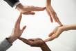 © fizkes - Close up bottom view concept of diverse business people join hands forming circle. Show unity and support, protection of business. Multiracial colleagues involved in team building activity.